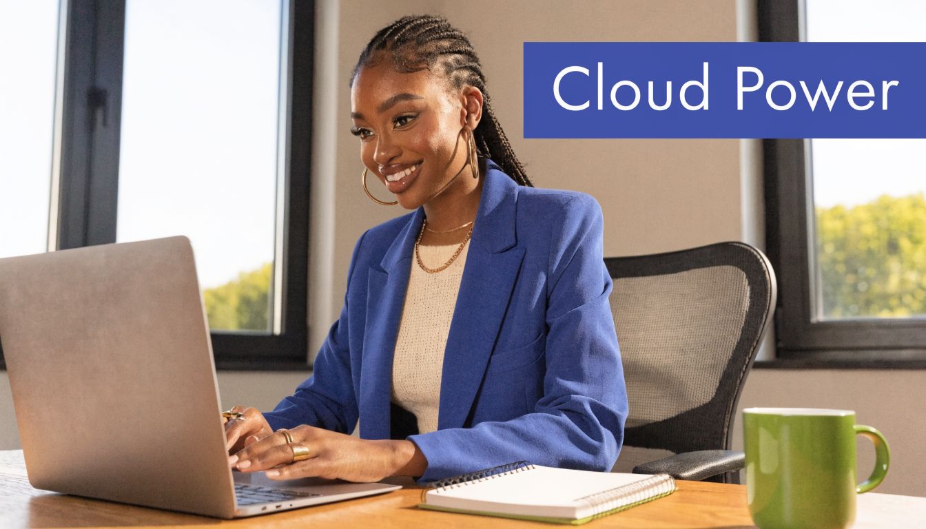 A professional Black woman in a blue blazer works on a laptop in a bright modern office.